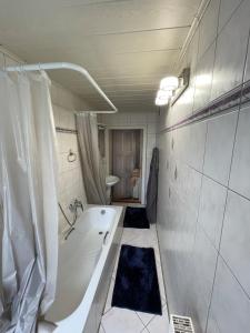 a white bathroom with a tub and a sink at Nussknackerstube in Seiffen +19 photos