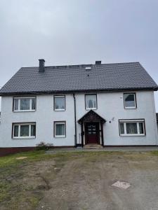 a white house with a door and a yard at Nussknackerstube in Seiffen