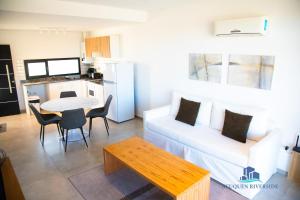 a living room with a white couch and a table at Neuquen Riverside in Neuquén