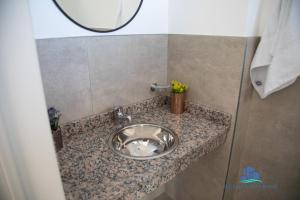 a silver sink in a bathroom with a mirror at Neuquen Riverside in Neuquén +26 photos