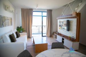 a living room with a white couch and a tv at Neuquen Riverside in Neuquén