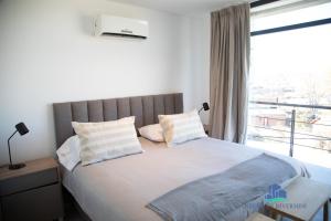 a bedroom with a large bed with a window at Neuquen Riverside in Neuquén