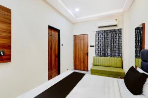 um quarto com uma cama e uma cadeira verde em Hotel O Kant em Durg