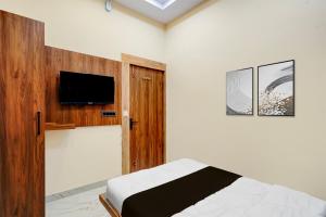 um quarto com uma cama e uma TV de tela plana em Hotel O Kant em Durg