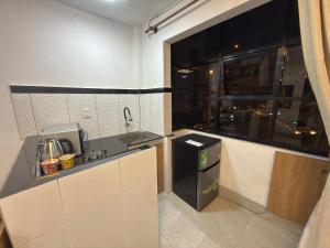 una pequeña cocina con fregadero y lavavajillas en Surapata Central Lounge, en Sucre