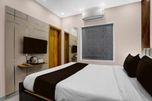 a bedroom with a large bed and a television at Super Townhouse Puri Bypass Crossway Formerly Hotel Pratee Heights in Bālianta