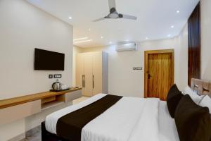 a bedroom with a large bed and a television at Super Townhouse Puri Bypass Crossway Formerly Hotel Pratee Heights in Bālianta