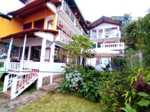 a white building with a bunch of plants in front of it at Hotel Victoria Atitlan in San Pedro La Laguna +20 photos