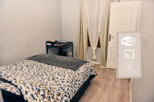 a bedroom with a bed and a table next to a door at Le Petit Céleste sur Seine in Choisy-le-Roi