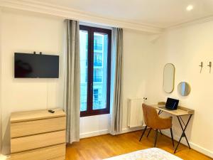 Dieses weiße Zimmer verfügt über einen Schreibtisch und ein Fenster. in der Unterkunft Maison Villa Foch in Meaux