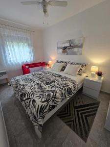 a bedroom with a bed with a black and white comforter at Apartments Lora in Vir