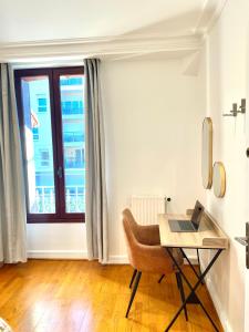 ein Zimmer mit einem Schreibtisch und einem Stuhl und einem Fenster in der Unterkunft Maison Villa Foch in Meaux