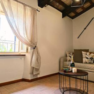 ein Wohnzimmer mit Sofa und Tisch in der Unterkunft Locanda la Rocca Residenza d'Epoca in Fossombrone