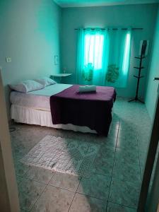 HOSTEL MEIRE pernoite في جوارولوس: غرفة نوم بسرير كبير مع بطانية ارجوانية