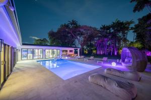 una casa con piscina por la noche en Two Neighboring Villas in The Heart of Miami, en Golden Glades