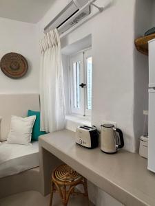 a kitchen with a counter with a toaster and a window at Cycladic Home Vorea in Ios Chora