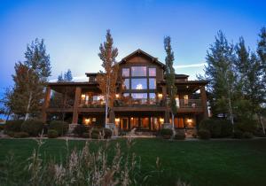 a large wooden house with a large deck at Spring Shores Lodge - Luxury Mountain Experience! in Ashton