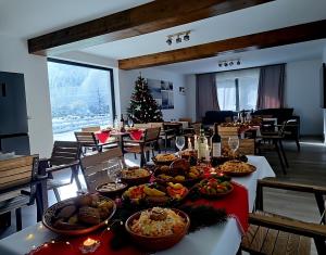 a long table with food on it with a christmas tree at Artizan Chalet in Topliţa