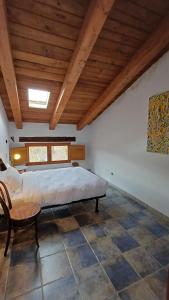 ein Schlafzimmer mit großem Bett und Holzdecke in der Unterkunft Molino Del Búho in Torre la Cárcel