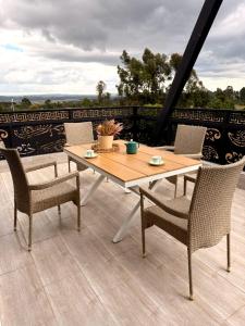 Le Satima Farmhouse في Nyahururu: طاولة وكراسي خشبية على الفناء