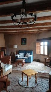 ein Wohnzimmer mit einem blauen Sofa und einem Tisch in der Unterkunft Molino Del Búho in Torre la Cárcel