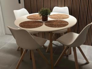 una mesa blanca con cuatro sillas y una planta en ella en PARQUE AROMATICO CON DOS PISCINAS, en Torrevieja