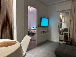 Una habitación con una cama y un televisor en una pared. en PARQUE AROMATICO CON DOS PISCINAS, en Torrevieja