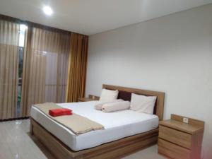 ジョグジャカルタにあるHyarta A1の白いシーツと枕が備わったベッドのある寝室