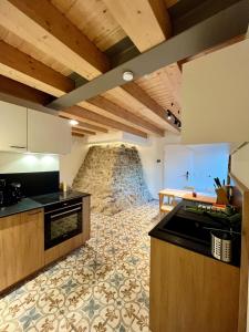 una cucina con mobili in legno e un muro in pietra di Gîte Koerich a Koerich