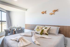 a bedroom with a bed with towels on it at Max Carneiros Suítes - Conforto e sofisticação há alguns passos do mar! in Tamandaré +35 photos