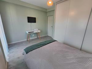 una camera da letto con un letto e una TV a parete di Vivo Metro Amethyst noua noua a Floreşti