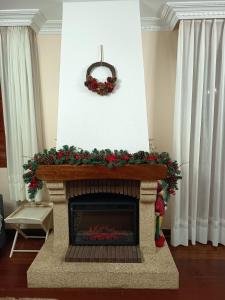 a living room with a fireplace with a christmasreath at Casona La Zampuca in Gijón