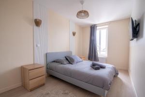 ein kleines Schlafzimmer mit einem Bett und einem Fenster in der Unterkunft La Parenthèse - Proche Puy du Fo u - 2 appartements équipés et confortables au coeur des Herbiers in Les Herbiers