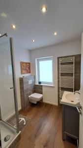 a bathroom with a shower and a toilet and a sink at Bed and Breakfast Orange-Inn in Krefeld