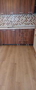 een lege keuken met een wastafel en houten kasten bij Rayon Apart hotel in Marmaris