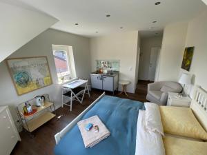 a living room with a blue bed and a desk at Bed and Breakfast Orange-Inn in Krefeld