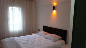een slaapkamer met een wit bed en een raam bij Rayon Apart hotel in Marmaris