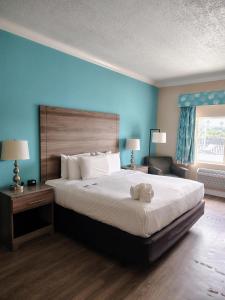 una camera da letto con un letto grande e una parete blu di Amelia Hotel at the Beach a Fernandina Beach
