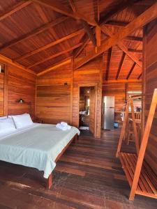 Canto do Mar - Atins - Lençóis Maranhenses في أتينز: غرفة نوم مع سرير في غرفة خشبية