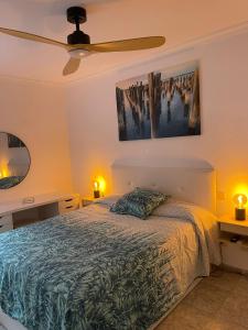 une chambre avec un lit et un ventilateur de plafond dans l'établissement Apartamento Tanzanita, à Costa Calma