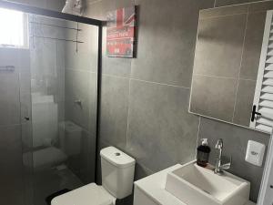 ein Badezimmer mit Toilette, Waschbecken und Dusche in der Unterkunft Havana Flats in Balneário Gaivotas + 28 Fotos