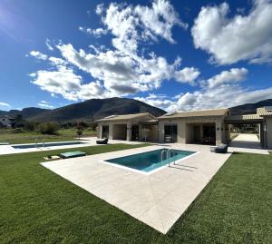 Olive Grove Villas Galaxidi في غالاكسيدي: منزل به حوض سباحة في الفناء