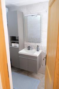 een badkamer met een wastafel en een spiegel bij House Robinson house in Dolac