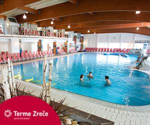 three people swimming in a large swimming pool at Mia's room in Zreče +17 photos