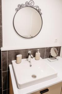 a bathroom sink with a round mirror above it at Elegantes Apartment in Bad Pyrmont