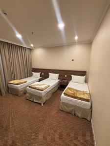una habitación de hotel con dos camas en una habitación en فندق التوحيد بارك 1 توصيل مجاني للحرم, en Al ‘Azīzīyah 20 fotos más