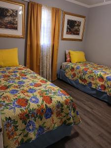 a bedroom with two beds with a colorful quilt at Macon Duplex Getaway | 3BR, WiFi, BBQ & Parking in Riverside Park