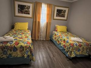 a bedroom with two beds with yellow pillows at Macon Duplex Getaway | 3BR, WiFi, BBQ & Parking in Riverside Park +2 photos