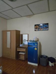 een keuken met een blauwe koelkast en een bureau bij ไร่ภูตะวัน in Ban Muang Ton Mamuang