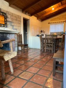 a room with a fireplace and a table and chairs at Cabañas La Moneda in Rancho La Carolina